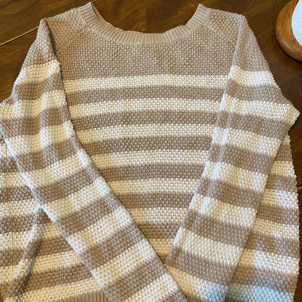 A sweater has a tiny in the front but not noticeable